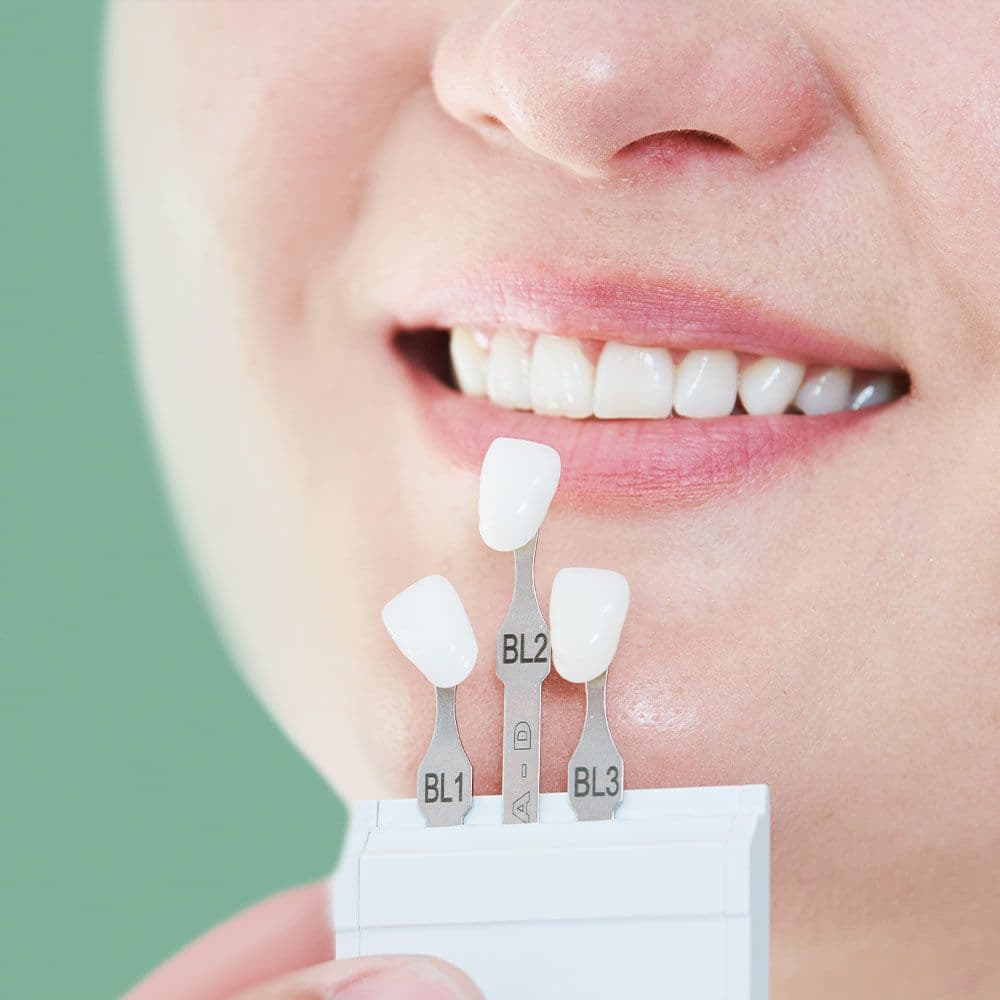 Fake teeth being held up to a patient's mouth
